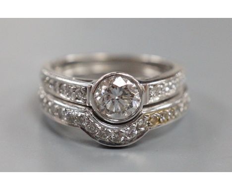 A modern 18ct white gold and collet set single stone diamond ring, with diamond set shoulders and 18ct and diamond set fitted