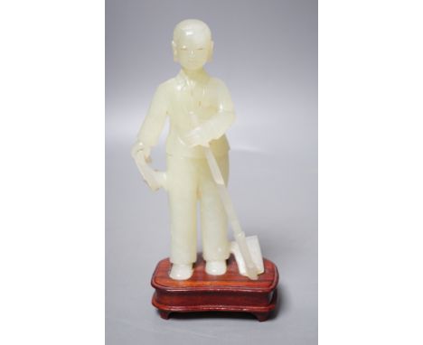 A Chinese carved bowenite jade figure of a worker on hardwood stand, 19cm