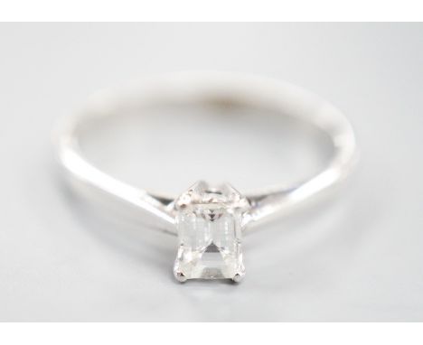 A modern 18ct white metal and solitaire emerald cut diamond set ring, size K, gross weight 2 grams, the stone weighing approx