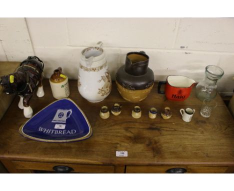 A stoneware harvest jug together with a Scotch whisky advertising jug; miniature harvestware jugs; an Edwardian floral decora