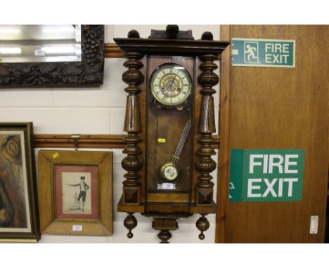 An early 20th Century walnut cased two hole Vienna wall clock