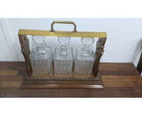 An early 20th century walnut and brass Tantalus with three decanters Location:If there is no condition report shown, please r
