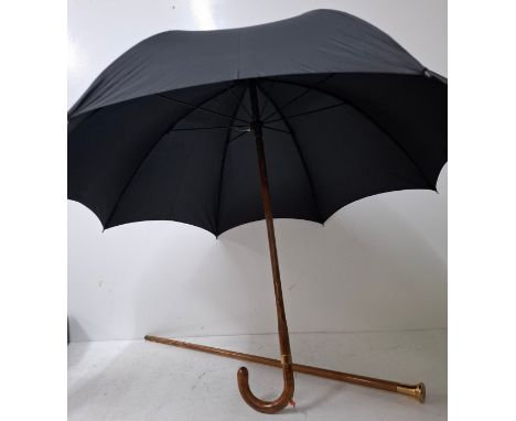 A Briggs London black umbrella with inset pencil having a gold tone collar signed Briggs together with a walking cane having 