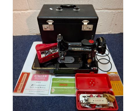 A 1957 Singer Featherweight 222K electric sewing machine having a black travel case together with a Singer 222k manual, a Sin