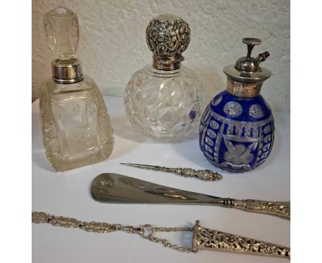 Three silver topped/collared glass scent bottles to include a blue flash cut example, makers marks RAD, together with a silve