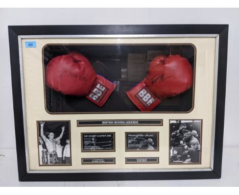 Two Britannia boxing gloves, one signed by Sir Henry Cooper, the other by Frank Bruno, mounted in a glazed box frame, with Wo