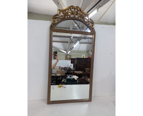 A late 19th/early 20th century gilt framed wall hanging mirror with decorative floral scrolled moulding, 107cm h x 51cm wLoca