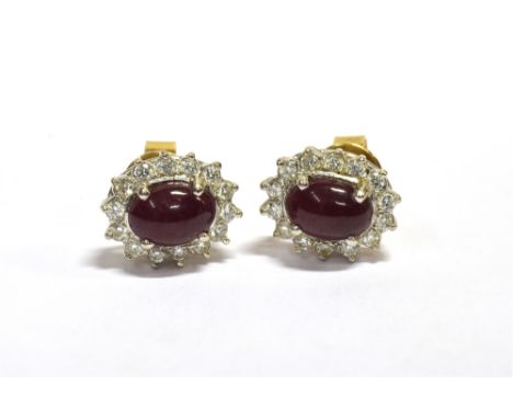 RUBY &amp; DIAMOND CLUSTER EARRINGS 11.1 X 9.5mm oval claw set cluster studs, set with central oval cabochon rubies, estimate