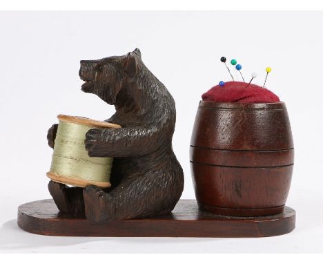 Black Forest bear form cotton reel holder and barrel form pin cushion, on a shaped plinth base, 14cm wide, 9cm high