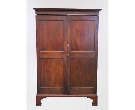 George III mahogany Channel Islands wardrobe, the cornice above a pair of panel doors on bracket feet, 132cm x 61cm x 196cm