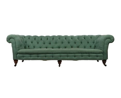 Victorian Chesterfield four seater settee, with green fir tree decorated button upholstery, raised on turned feet and castors