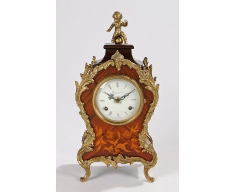 Gilt metal mounted ormolu clock, the cherub finial above a waisted outline case and curved feet, a white dial with Roman hour