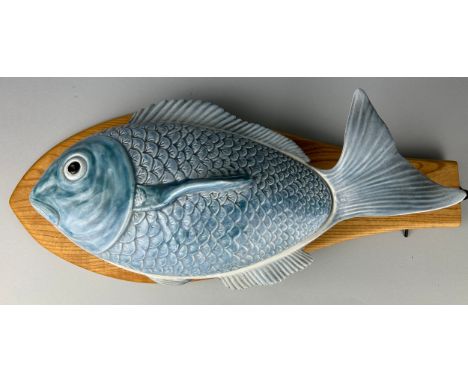 A LARGE CERAMIC FISH ON A SHAPED HANDMADE WOODEN PLATTER 