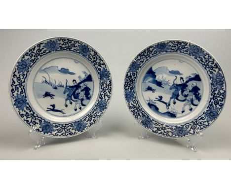 A NEAR PAIR OF CHINESE PORCELAIN KANGXI DISHES, Qing dynasty (1644-1912), Kangxi reign (1662-1772) blue and white depicting t