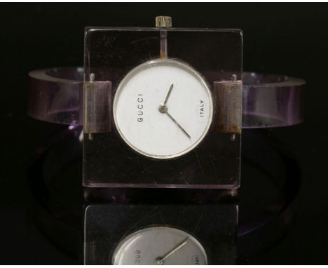 A ladies Gucci mechanical perspex watch, c.1970, with a circular silver white dial to a purple perspex square head.  Skeleton