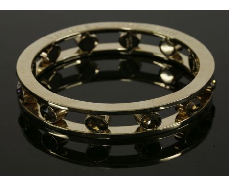 A two-row flat section Orka bangle,by Michael Teperson, with a central row of smokey quartz coloured paste in individual rub 