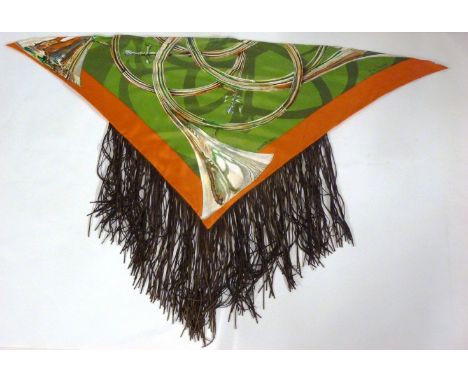 An Hermès silk scarf,with brown leather tassel trim, designed by T de Linares, a green ground with orange border and printed 