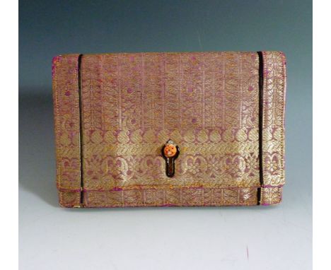 A Cartier Art Deco magenta and metallic gold thread woven Indian fabric evening clutch bag,with a gold and black enamel keyho