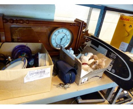 Shelf of mixed items including clock, skateboard, teddy bears