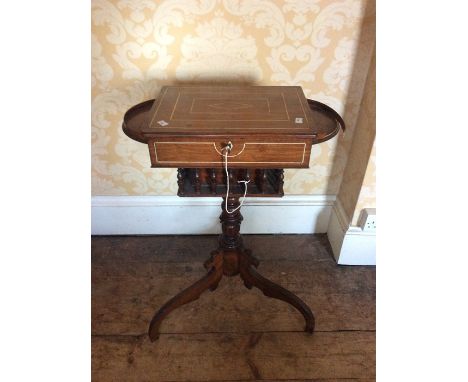 A William IV rosewood teapoy with demi lume shelves on each side, circa 1830, with turned supports on the undertier on a turn