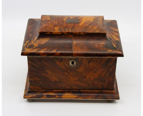 A Regency style tortoiseshell tea caddy, of sarcophagus from, interior with twin lidded compartments, metal ball feet, width 