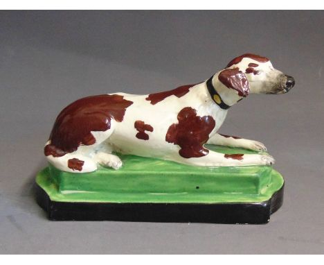 A Staffordshire model of a setter laying on an oblong base, circa 1820, 17.5cm wide and 9cm highCondition: chip to rear base 