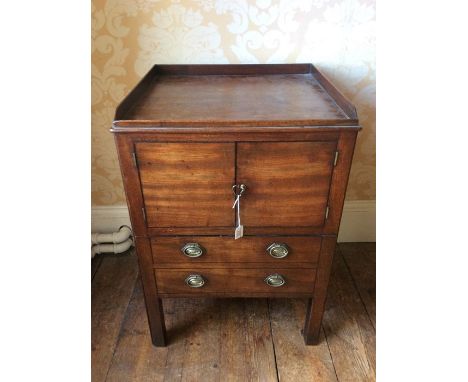 A George III oak commode, circa 1780, rectangular top above a two door cupboard with two short oval brass handled drawers bel