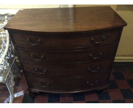 A George III mahogany bow front chest of four long graduated drawers with brass handles on carved bracket feet, circa 1800.