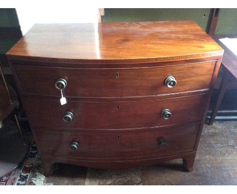 A George III mahogany bow front chest of drawers, circa 1800, square inlay pattern above three long graduated with brass turn