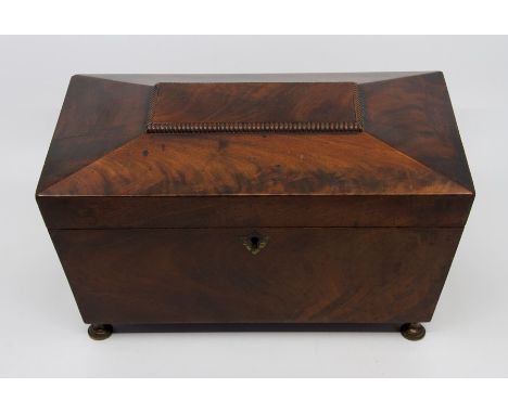 A Regency mahogany tea caddy, circa 1820, of sarcophagus form, triple division interior with covered compartments and a centr