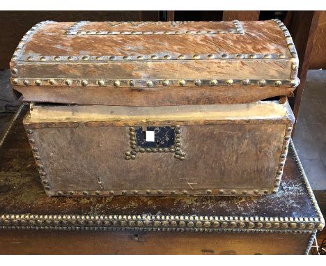 A George IV Cowhide trunk, circa 1825, brass beaded decoration around the edge with metal locks and handles.