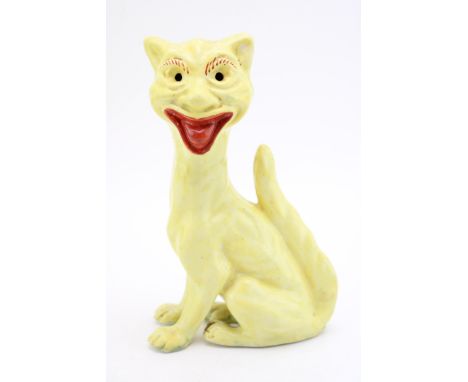 An unusual grotesque pottery cat in yellow colourway, raised tail and sticking her tongue out, possible Aller Vale, indistinc