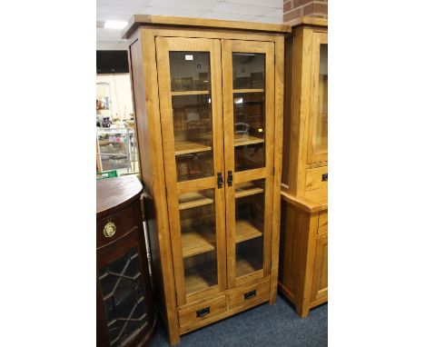 A MODERN LIGHT OAK GLAZED TALL FLOOR STANDING BOOKCASE W 89 CM