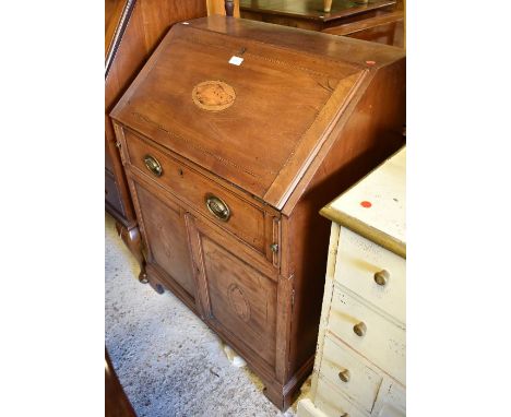 A shell inlaid mahogany fitted bureau over a single drawer and pair of cabinet doors, on shaped bracket feet, 71 cm x 46 cm x