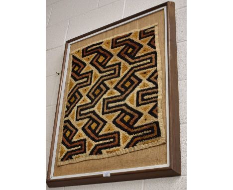 A geometric abstract textile panel, framed