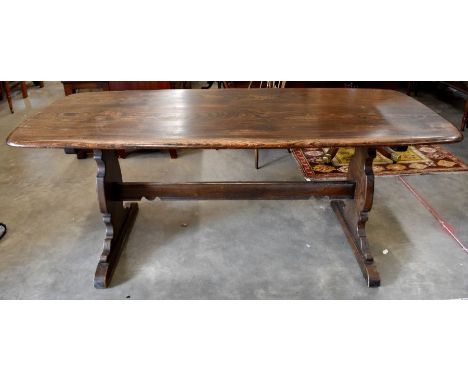 An Ercol dark elm refectory style dining table with shaped supports and pegged stretcher, 182 cm x 80 cm x 72 cm h, to/w a se