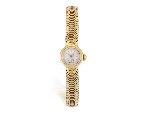 A LADY’S MECHANICAL GOLD WRISTWATCH, BY MOVADO, the circular cream dial with baton hour markers and hands, within a round cas