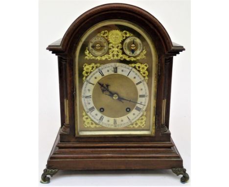 A late 19th century German mahogany bracket clock with arched top, the brass mask with cast spandrels, the silvered dial sign
