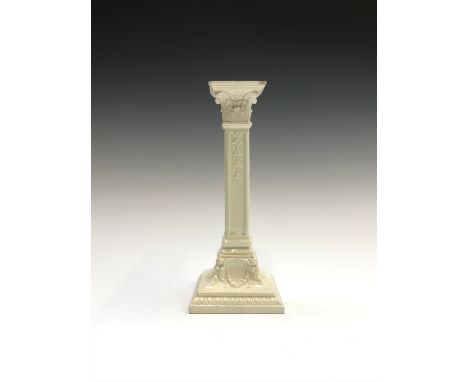 A late 18th century creamware candlestick modelled as a Corinthian column with mask and swag decoration. Height 25cm.