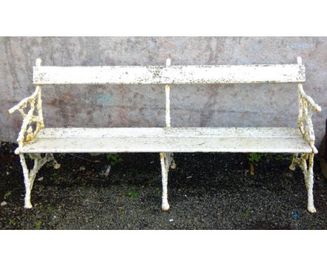 A Victorian garden bench, the cast iron ends and centre decorated with ivy covered branch decoration, with back rail and two 