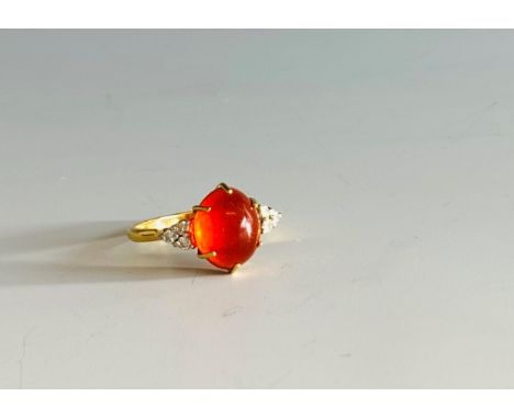 An 18ct gold fire opal ring each shoulder with a diamond trefoil.Condition report: The opal 11.6 x 9.2mm x 6.7mm deep minimal