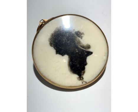 An 18th century gold mounted memorial locket, with a silhouette portrait of a lady, plaited hair to the back, with gold initi