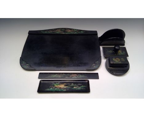 An Art Deco style black lacquered desk set, comprising inkwell, blotter, pen tray, ruler, letter rack and tray.