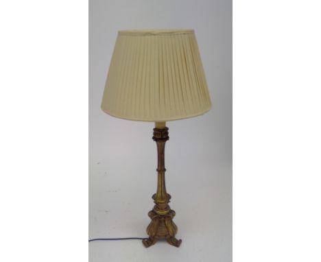 A gilt painted wood table lamp with tripod base, with shade. Overall height of lamp 65cm.