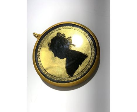 A verre eglomise silhouette portrait of a lady, in gilt metal pendant mount.