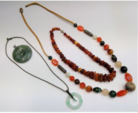 Two Chinese jade bi pendants, an amber necklace and a Chinese necklace with carved hardstone beads and cloisonne cylindrical 