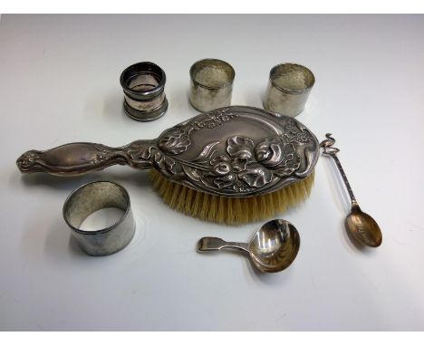 A Victorian silver caddy spoon, an ornate Art Nouveau silver mounted brush, three Cornish tin napkin rings and one other napk