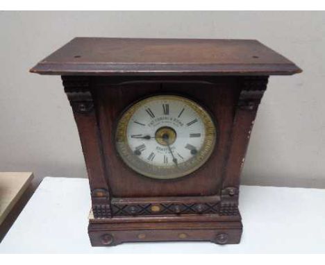 An Edwardian oak cased mantel clock with silvered and enamelled dial by Fattorini and Sons, Bradford.