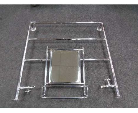 A chrome heated towel rail together with a bathroom mirror with shelf 