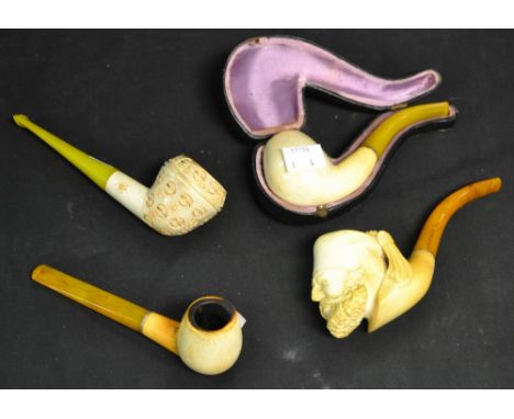 A Meerschaum novelty gentleman's pipe, the bowl as a Turk's head, amber-type mouthpiece; others (4)